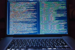Persona anónima frente a pantalla de computadora con alerta de filtración de datos