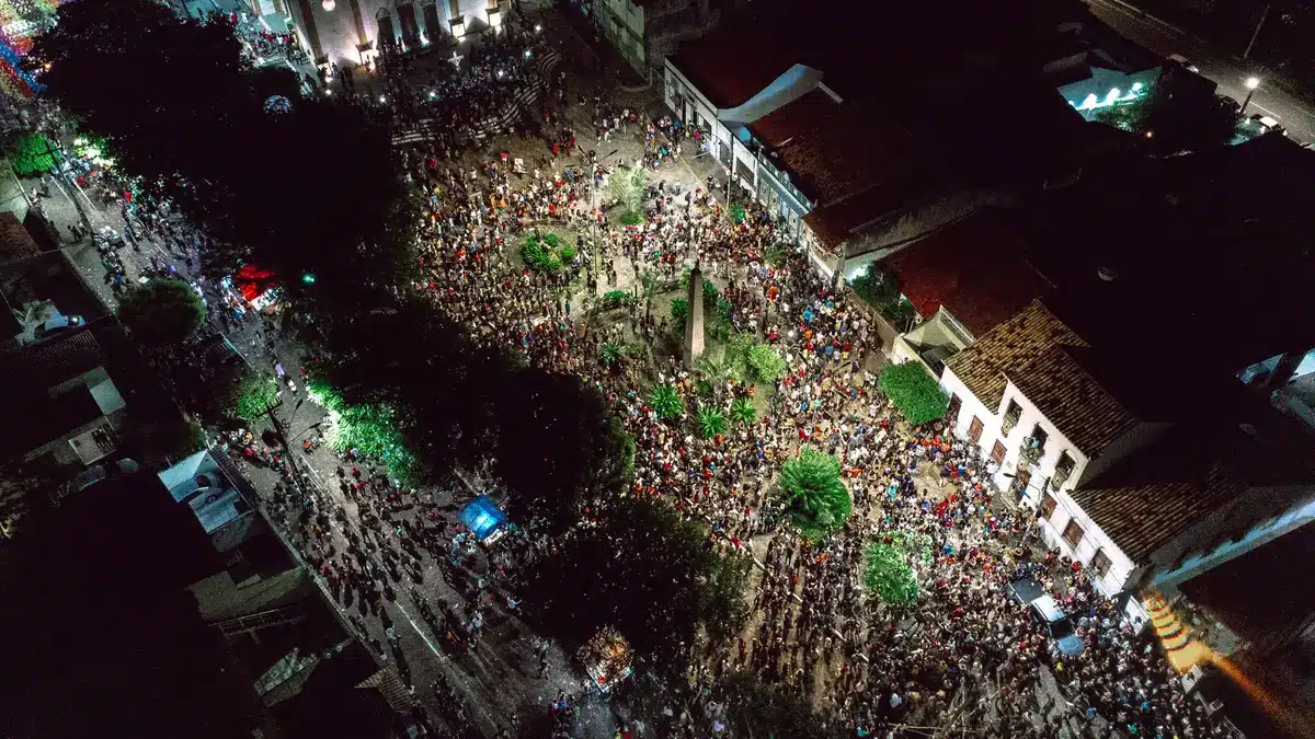 Multitud de personas en las calles de Pamplona durante las fiestas de San Fermín, con luces y ambiente festivo nocturno.
