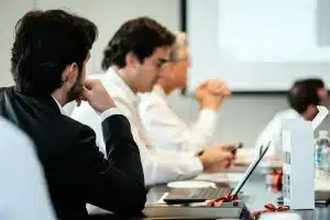 Reunión de ejecutivos empresariales en sala de juntas durante una votación formal