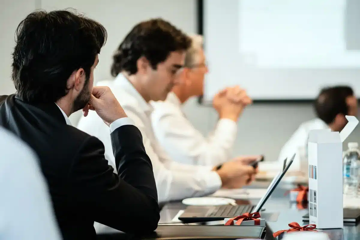 Reunión de ejecutivos empresariales en sala de juntas durante una votación formal