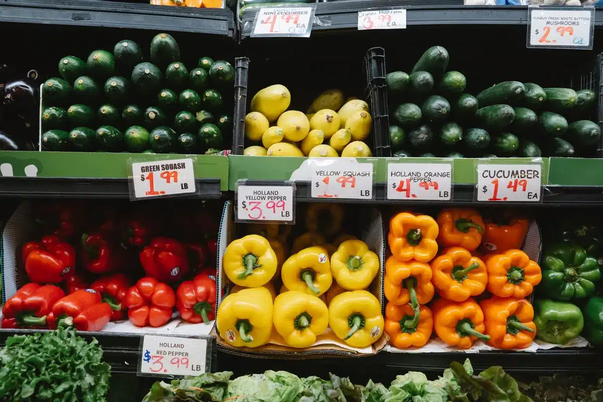 Carrito de compra con frutas y alimentos frescos en un supermercado, reflejando la moderación de precios en alimentos