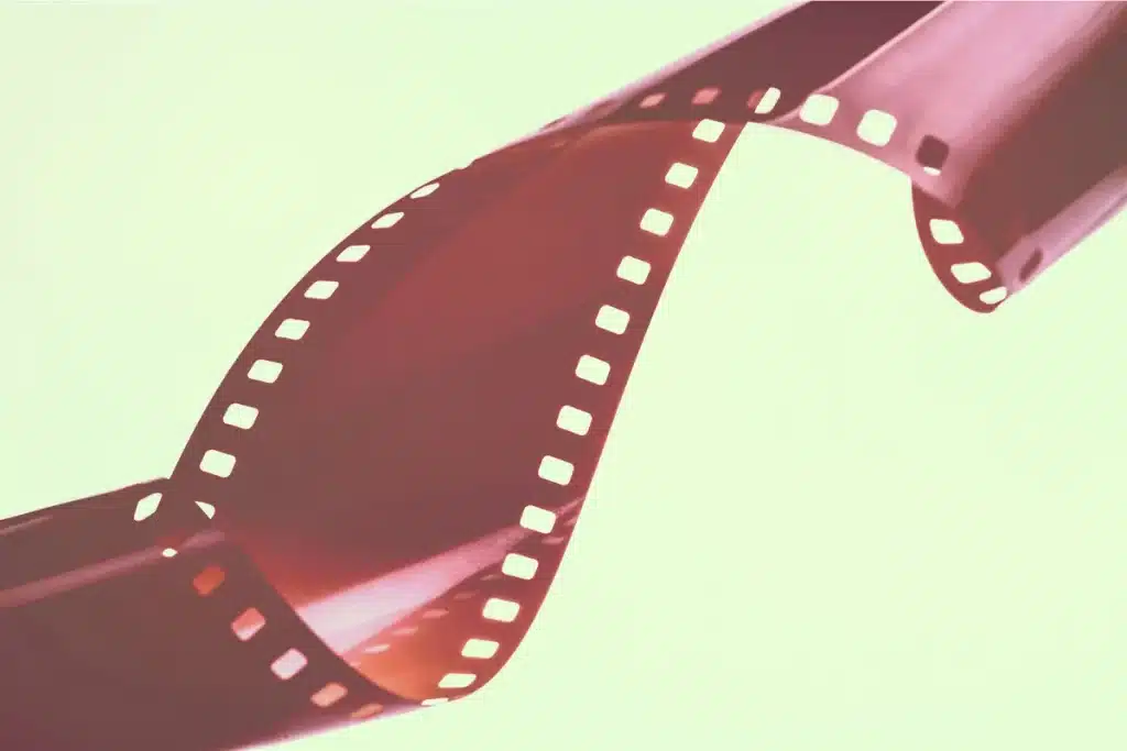 Bobinas de cine antiguas junto a dispositivo de streaming moderno, representando la evolución del cine