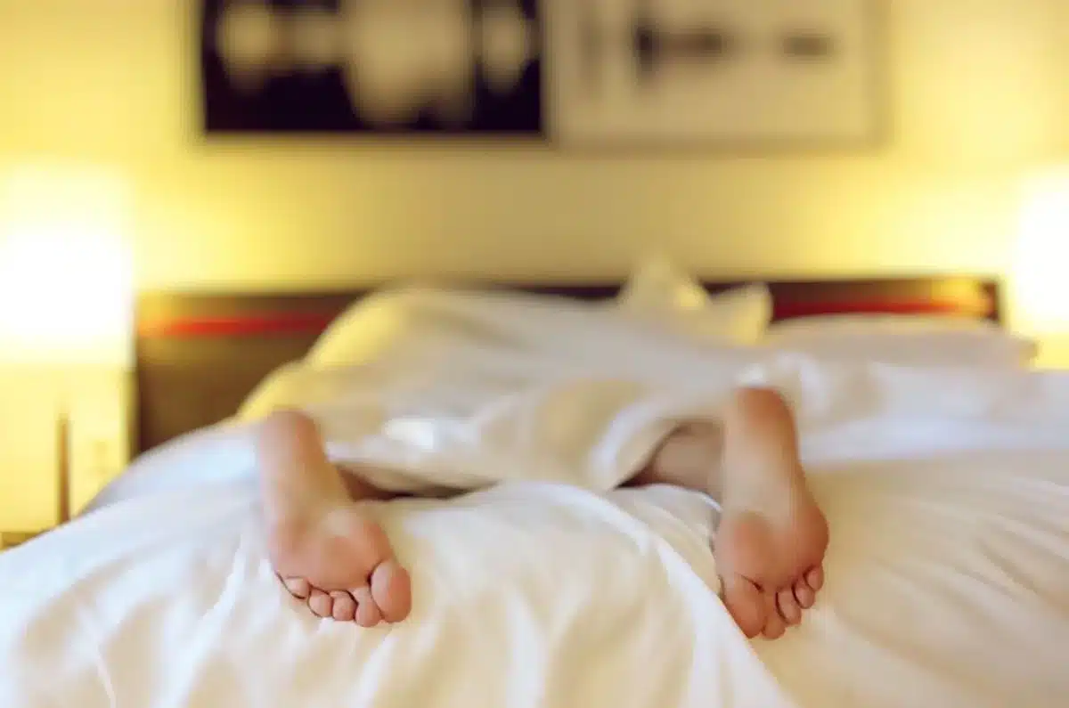 Persona en cama durante una noche cálida sin poder dormir