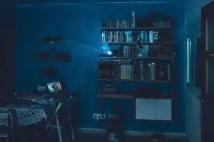 Sala de cine en casa con pantalla mostrando plataformas de streaming y palomitas de maíz