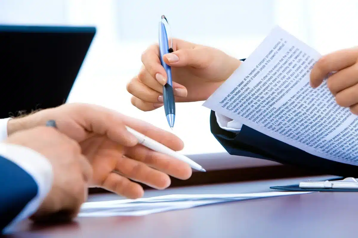 Manos revisando pasaportes y billetes en un mostrador de control sin rostros