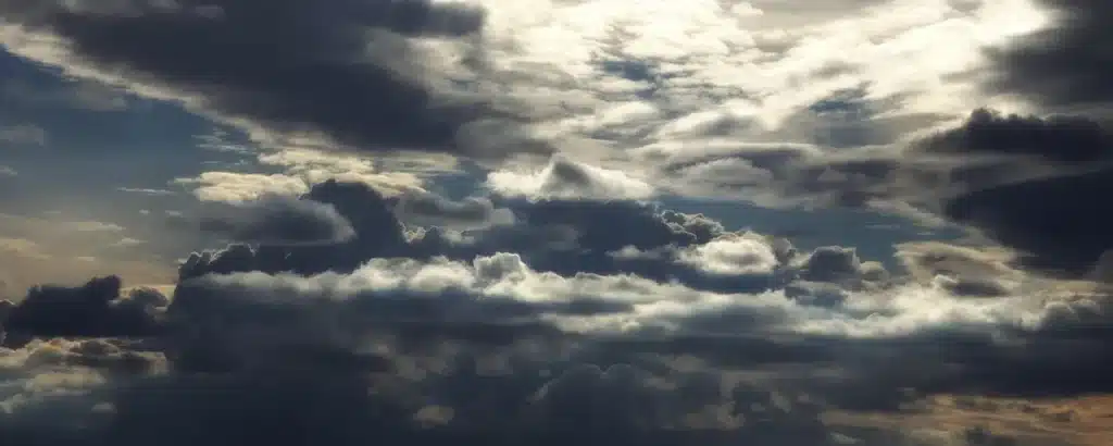 Promenade costera con gente anónima bajo paraguas y nubes de tormenta acercándose