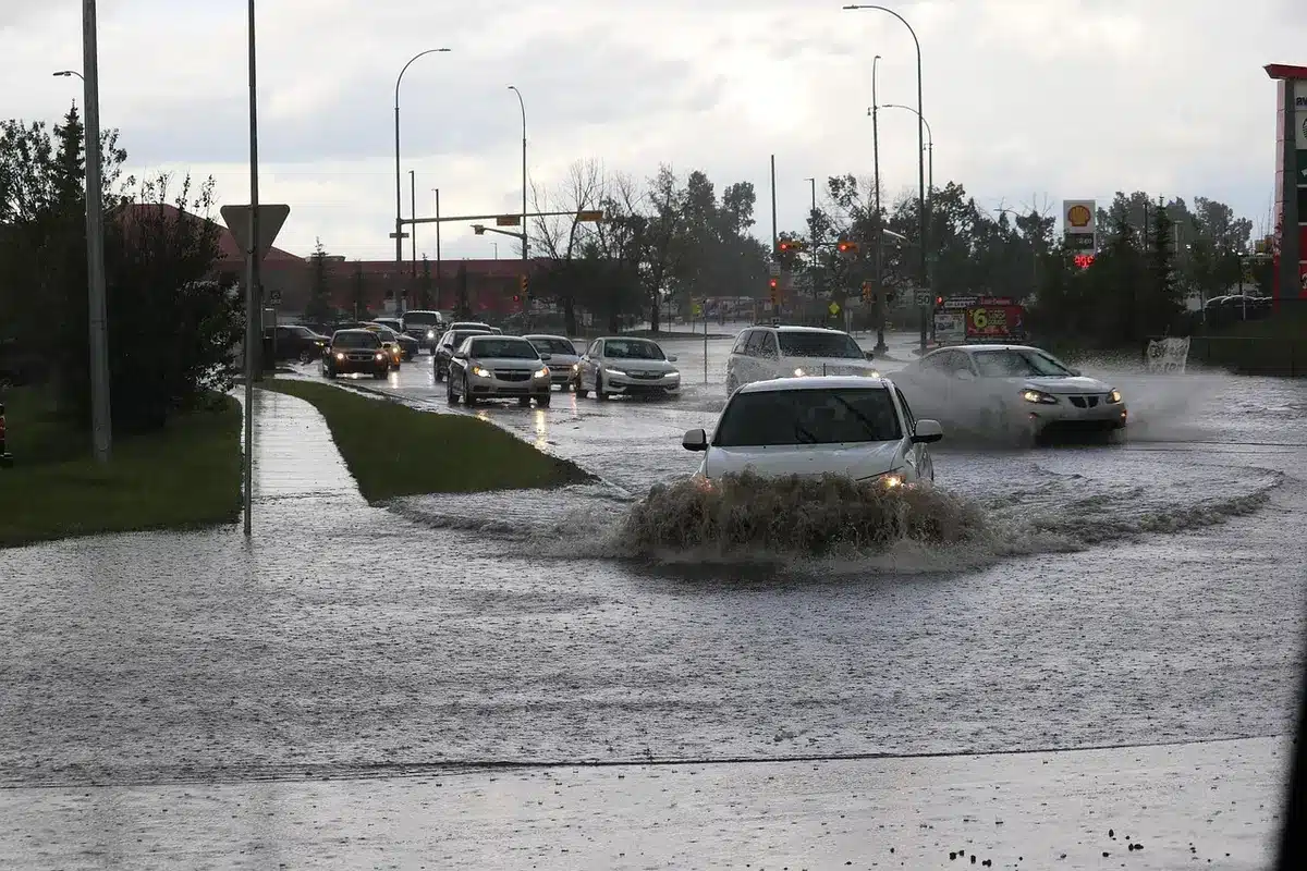 Señal de aviso y carretera inundada con precauciones visibles