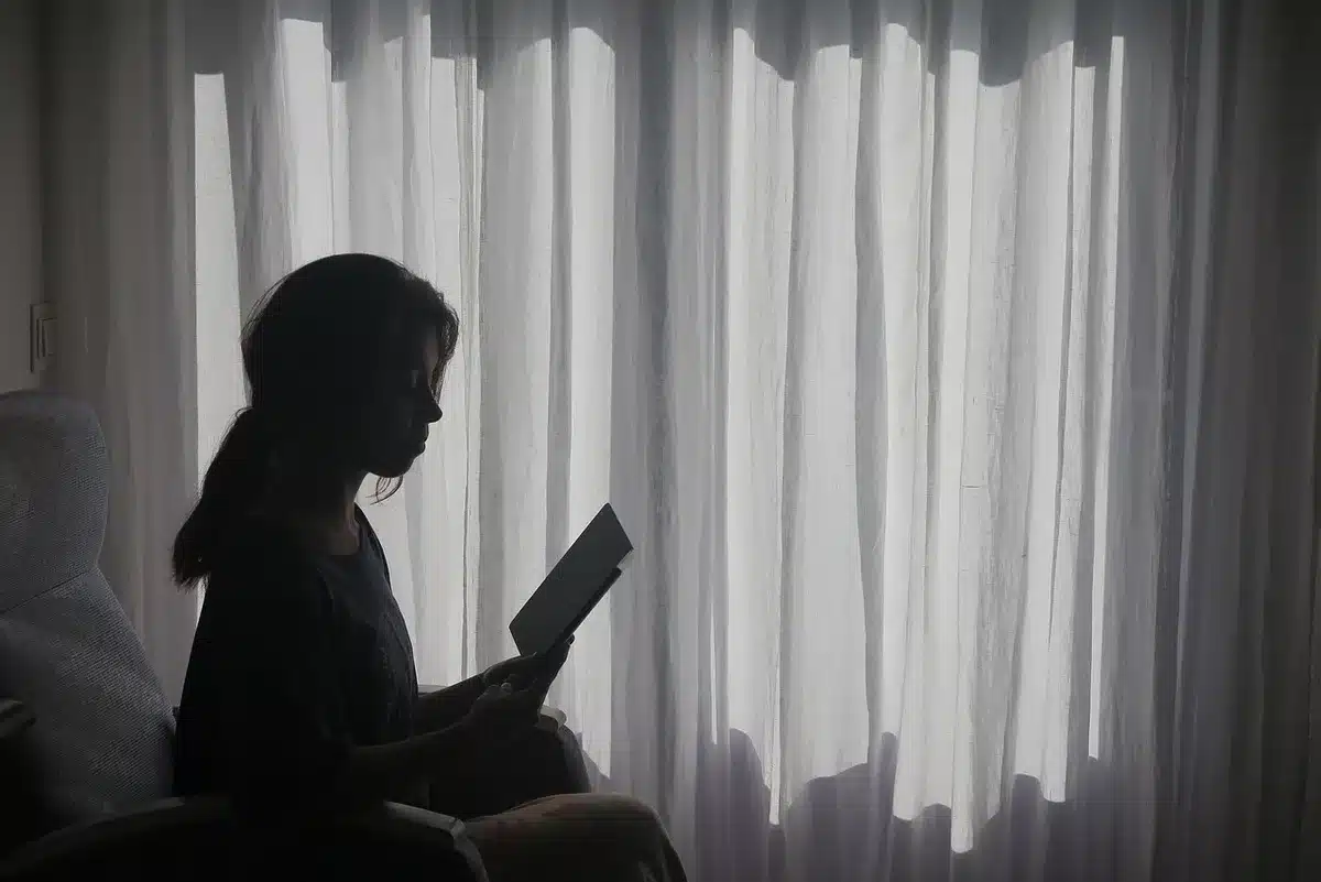 Mujer leyendo un manuscrito en un escritorio con expresión pensativa