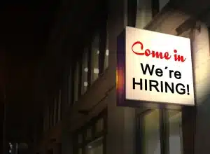 Personas en una oficina de empleo con luz natural, representando la búsqueda de trabajo en temporada estival