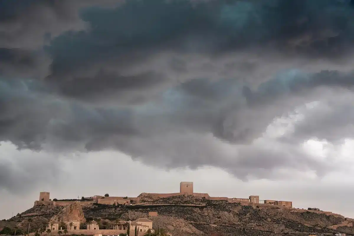 Nubes de tormenta oscuras y lluvia sobre el paisaje español en septiembre