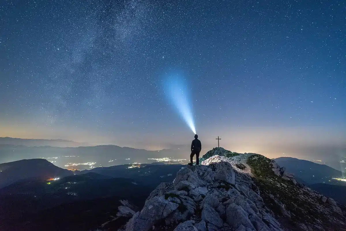Manos con linterna iluminando un túnel en un sótano junto a cajas de mudanza