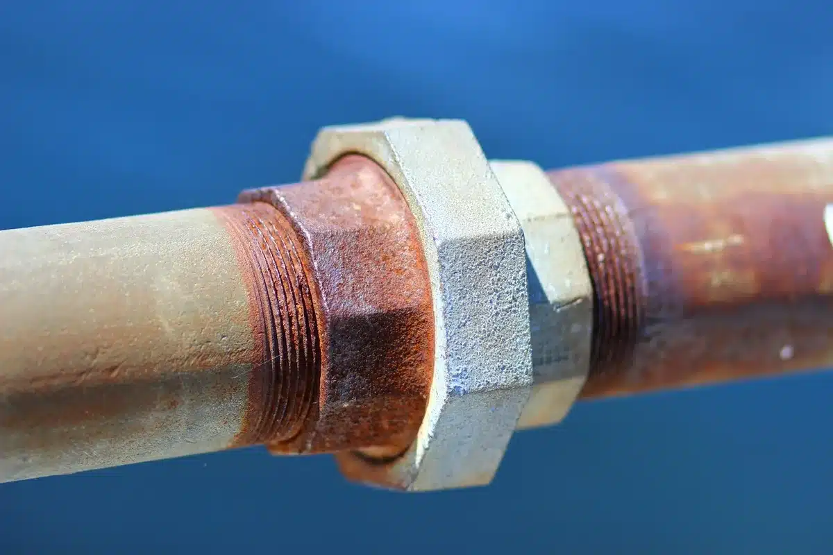 Técnico inspeccionando conductos metálicos y tuberías industriales