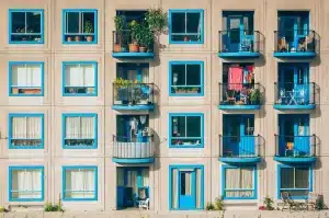 Escalera y pasillo de comunidad con puertas cerradas y tablón de anuncios