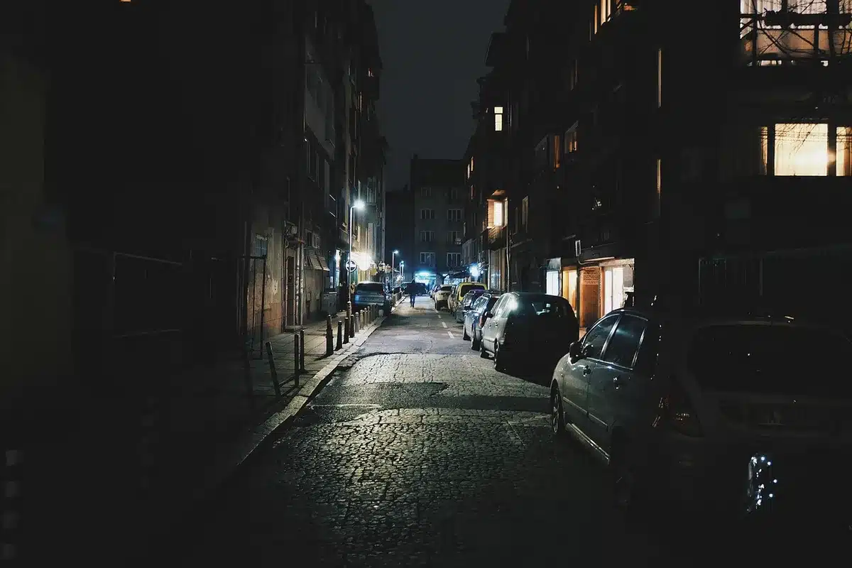 Calle urbana anegada con vehículos y corrientes de agua