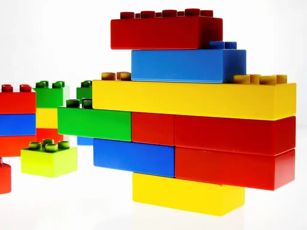 Manos apilando bloques modulares de plástico reciclado en una obra comunitaria
