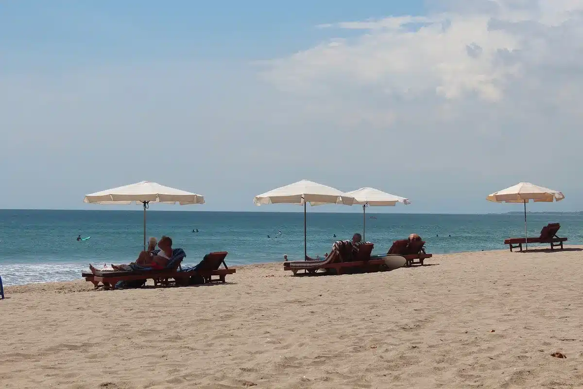 Sombrillas plegadas en una playa con una cámara de vídeo antigua y gafas de sol