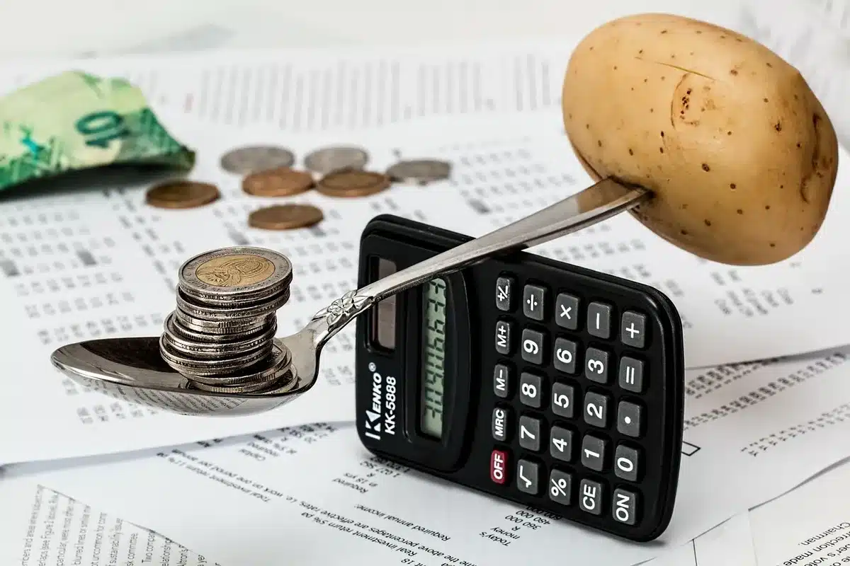 Manos con nómina y calculadora mostrando coste laboral y retenciones