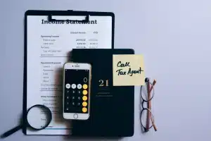 Escritorio con papeles de impuestos y calculadora, escena anónima en oficina doméstica