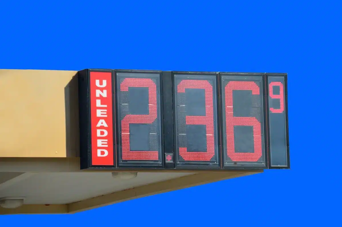 Surtidores de combustible y maletas en un mostrador de aerolínea, ilustrando combustibles y turismo