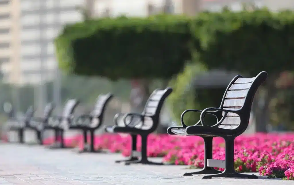 Plaza urbana con parque infantil vacío y tiendas improvisadas al fondo