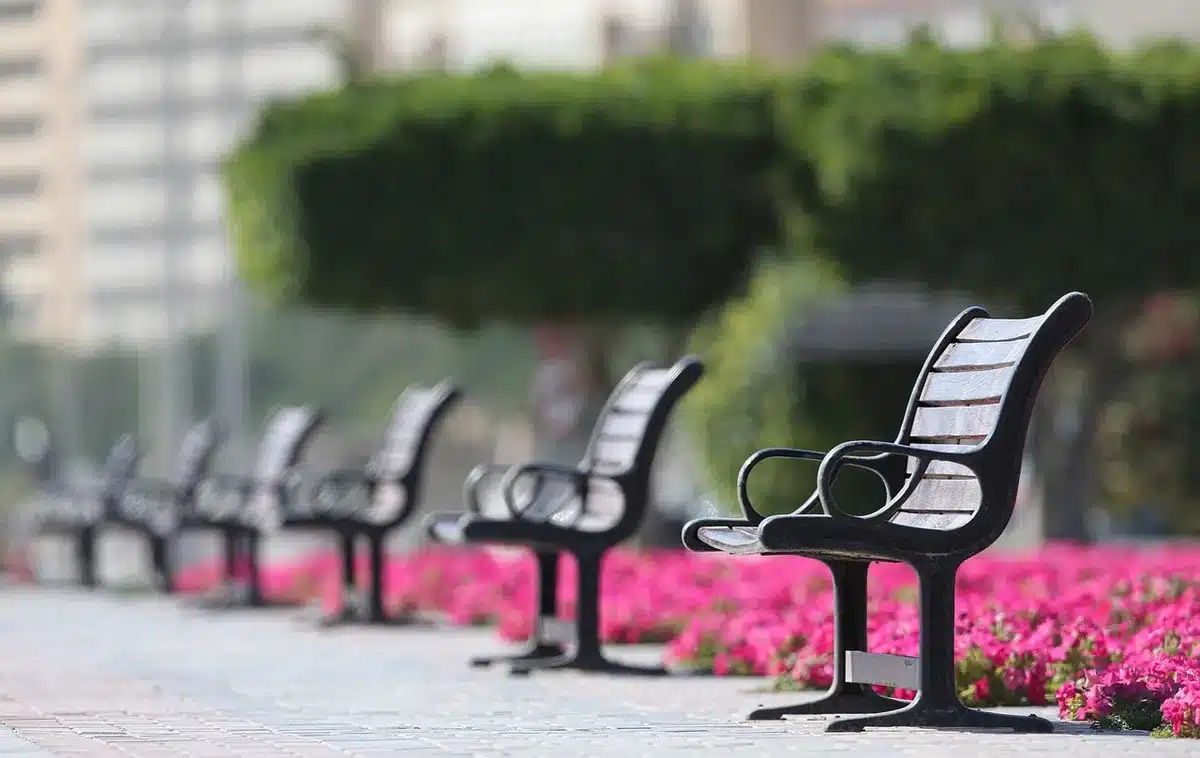 Plaza urbana con parque infantil vacío y tiendas improvisadas al fondo
