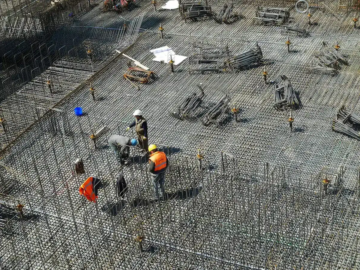 Reunión de supervisores en obra con cascos y planos